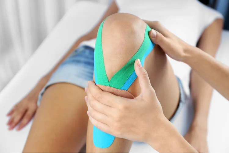 Therapeutic tape applied to support ACL-injured knee.