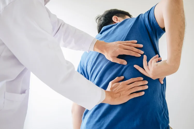 Back pain specialist examining patient for lower back pain diagnosis.