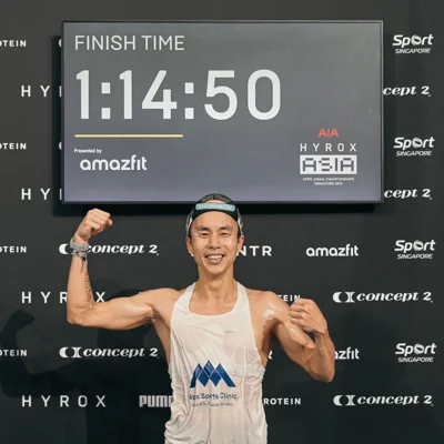 Dr. Foo Gen Lin celebrating strong finish time in HYROX emphasising training and injury prevention.
