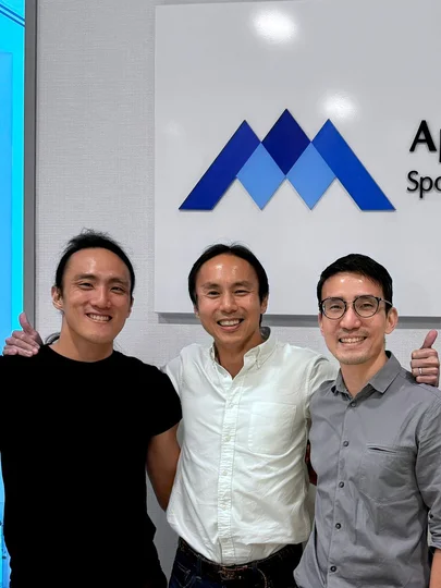 Dr Foo with patients and athletes outside Apex Sports Clinic offering sports medicine services.