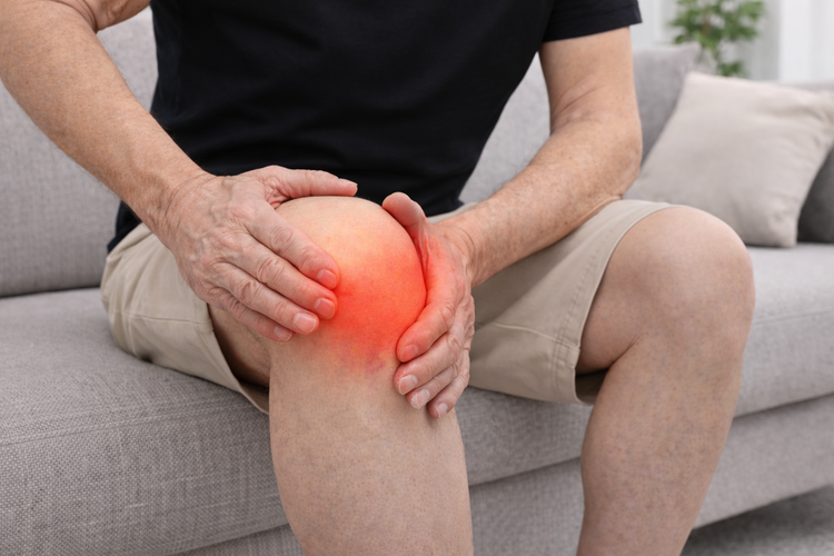 Man holding knee highlighted in red due to osteoarthritis and chronic pain.