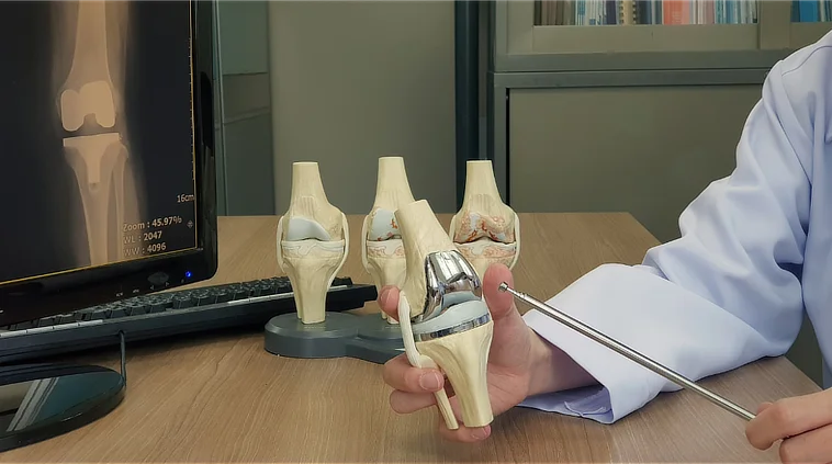 Orthopaedic surgeon explaining knee implants used in total and partial replacement procedures.