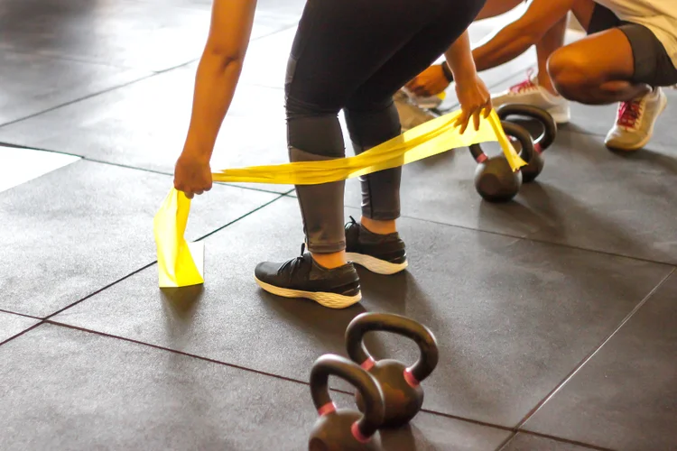 Woman doing resistance band exercise to strengthen muscles and reduce cartilage wear.