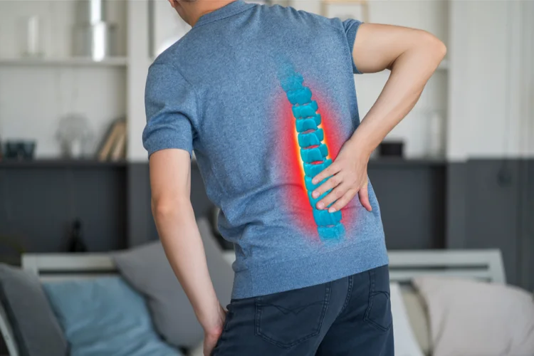 Man holding back with digital spine overlay indicating nerve pain.