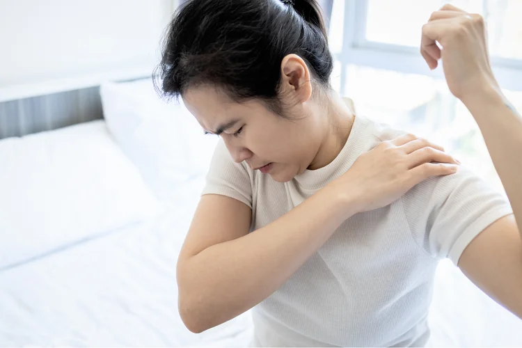 Woman experiencing shoulder pain from inflammation at home.