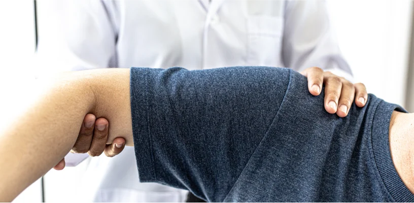 Doctor examining patient for shoulder pain and joint instability to diagnose dislocation.