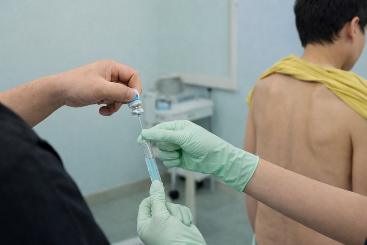 Specialist preparing syringe before an epidural steroid injection procedure.