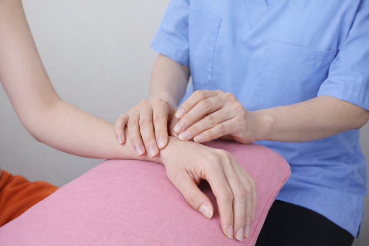 Hand specialist assessing wrist and finger movement to diagnose trigger finger.