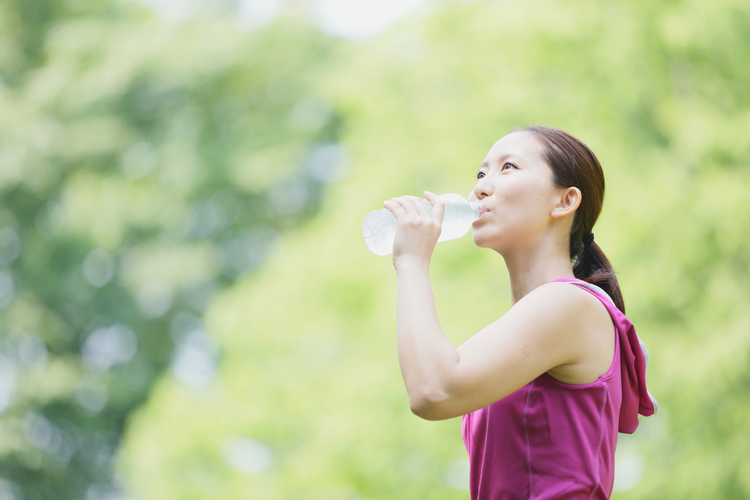 Woman hydrating after a marathon to support post-race recovery.